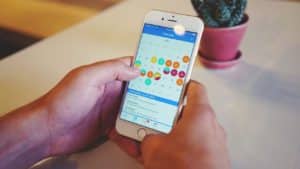 phone with a calendar open on the screen with different colored bubbles on dates.
