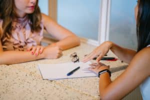 two women sitting at a table talking