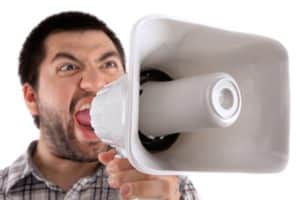 caucasian man yelling into a megaphone