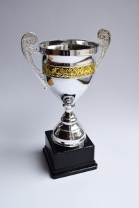 silver trophy with a gold band around the cup
