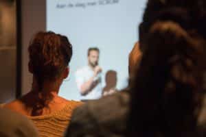 blurred photo of a man presenting in front of people