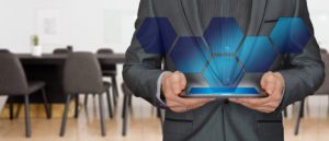 person in a suit holding a tablet with options over it