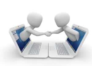 two people coming out of laptops shaking hands