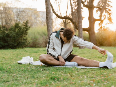 Person stretching outdoors in a park, practicing self-care and physical wellness. 