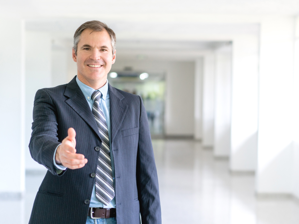 Health insurance agent reaching his hand out during a client meeting.